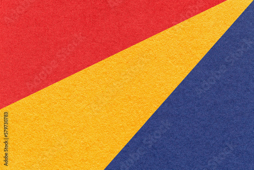Texture of old craft red, yellow and navy blue color paper background, macro. Vintage abstract cardboard