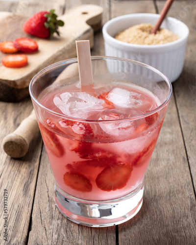 Wallpaper Mural Brazilian strawberry caipirinha in a glass with ice and fruits over wooden table Torontodigital.ca