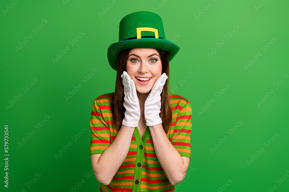 Photo of positive young lady in leprechaun suit impressed festive saint patrick discounts isolated on green color background Photo of positive young lady in leprechaun suit impressed festive saint patrick discounts isolated on green color background