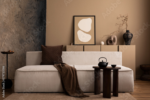Interior design of creative living room interior with mock up poster frame, modular sofa, wooden coffee table, brown plaid, pillow, vase with branch and personal accessories. Home decor. Template. © FollowTheFlow