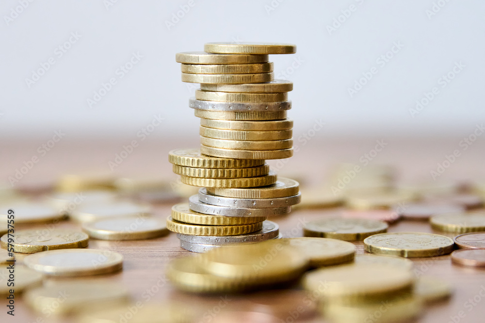 Pile of coins on a wooden table with shallow depth of field Pile of coins on a wooden table with shallow depth of field