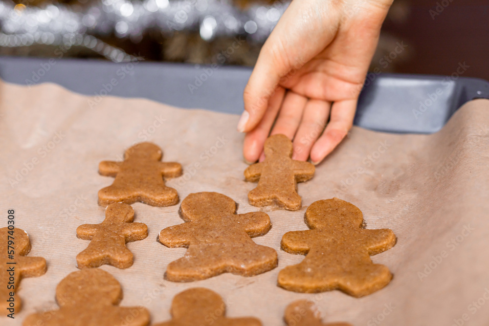 Raw gingerbread men's casseroles on a metal tray for baking. The process of making cookies at home, a family holiday concept. Raw gingerbread men's casseroles on a metal tray for baking. The process of making cookies at home, a family holiday concept.