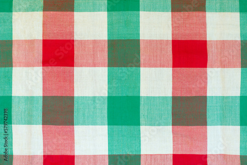 Red and green checkered tablecloth as background, closeup of photo
