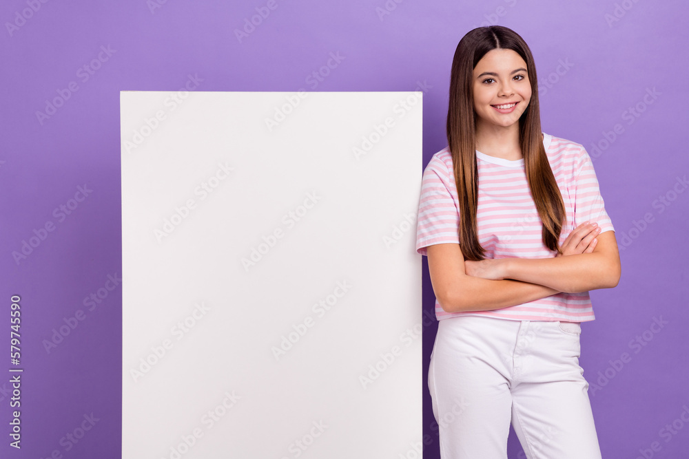 Portrait of lovely positive girl crossed hands toothy smile empty space placard isolated on purple color background Portrait of lovely positive girl crossed hands toothy smile empty space placard isolated on purple color background