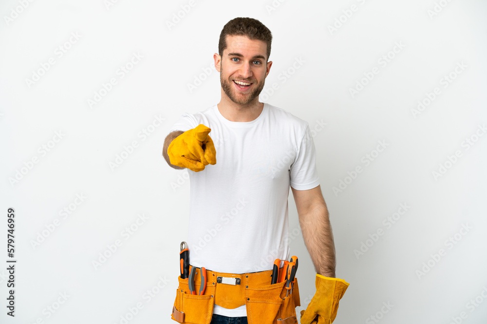 Young electrician man over isolated white wall surprised and pointing front Young electrician man over isolated white wall surprised and pointing front