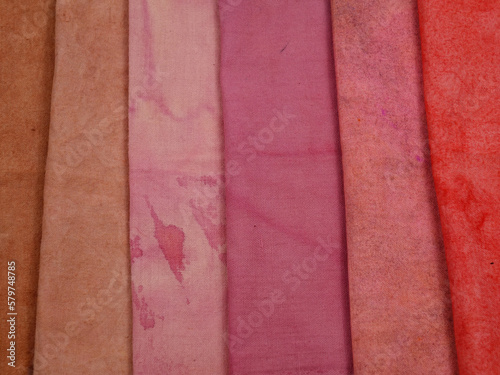 Samples of cotton fabric in light- dark red gradient, background.  Natural dyeing for fabrics, DIY    photo