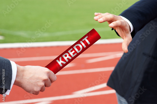 Handover of a red baton with german word Kredit means loan-depth restructuring
