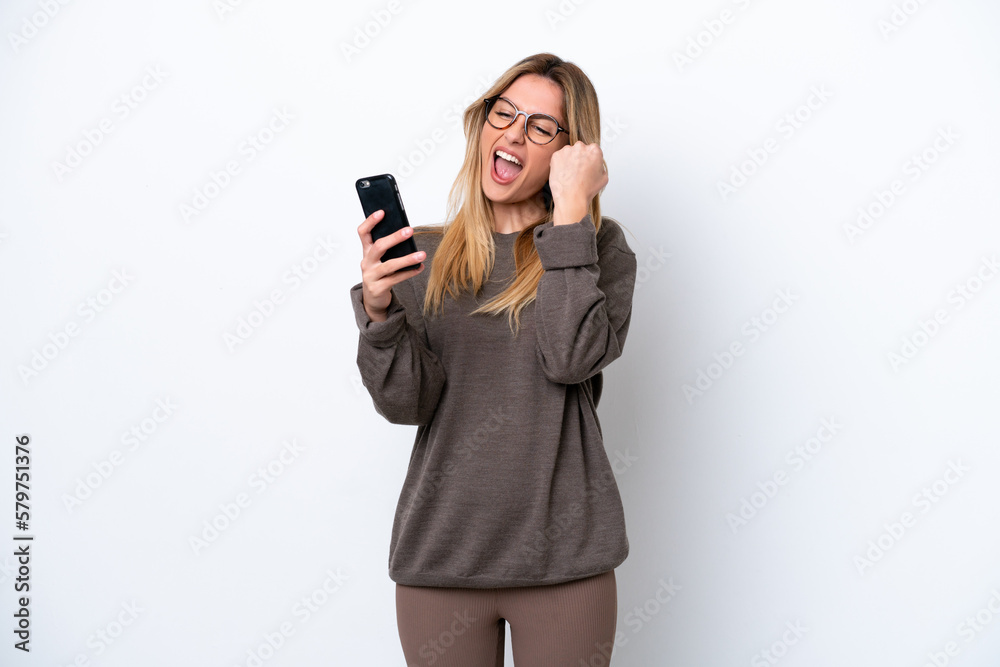 Young Uruguayan woman isolated on white background with phone in victory position