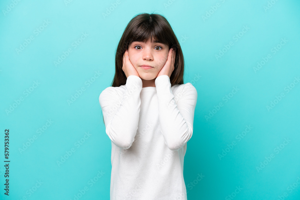 Little caucasian girl isolated on blue background frustrated and covering ears Little caucasian girl isolated on blue background frustrated and covering ears