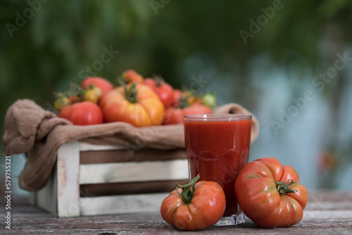 Fresh red tomato juice, on a wooden background
