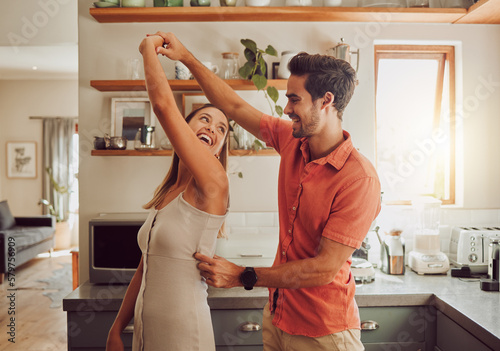 Joyful, dancing and loving couple bonding and having fun in the kitchen together at home. Energetic, fun and active relationship sharing a dance and romantic moment while enjoying their anniversary.