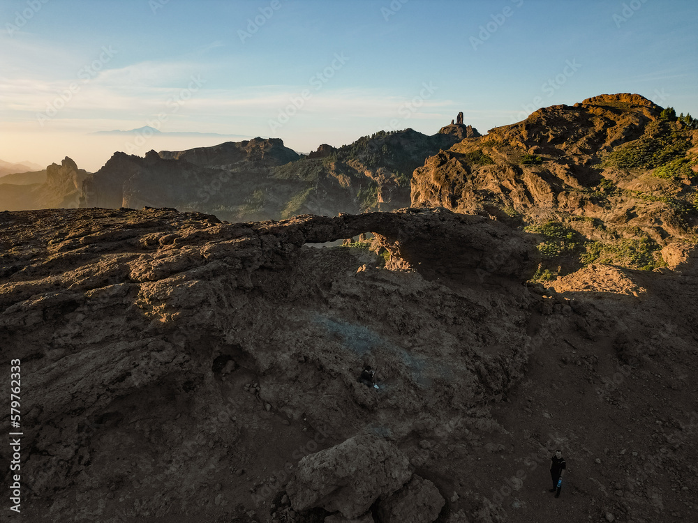 Aerial View of Rocky Mountains with Roque Nublo and Archway, and Mount Teide in the Background in Gran Canaria, Spain
