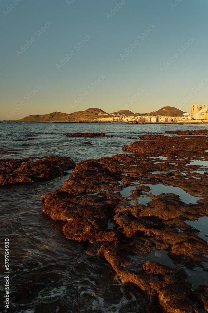Cityscape View with Rocks in the foreground in Las Canteras Beach, in Las Palmas de Gran Canaria, Spain