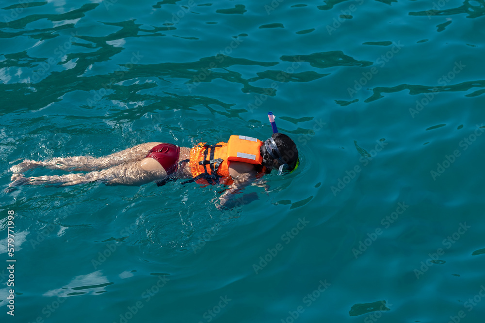 Young tourist female girl woman snorkeling with mask and pipe in the ocean water. Space for copy. Active lifestyle, adventure, extreme sports and activities, tourism and travel concept.