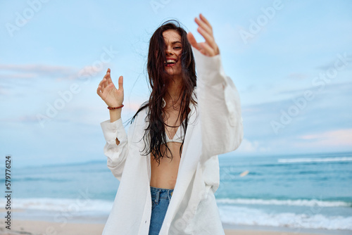 Fotografiet Brunette woman with long hair in a white shirt and shorts smile and happiness wa