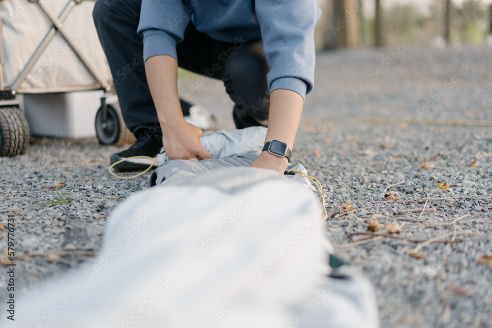 man is pitching tent in park