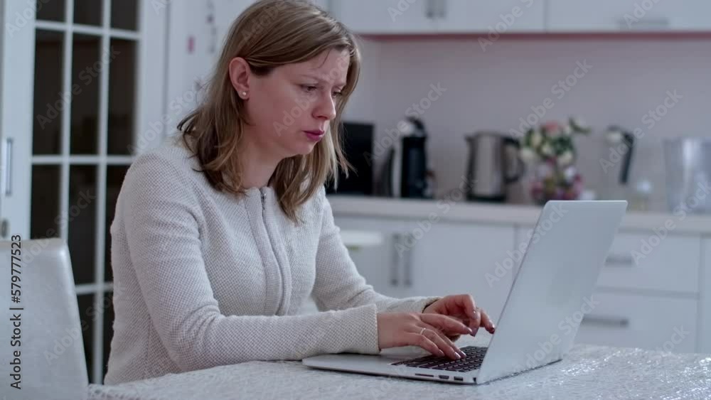 Woman in the kitchen typing on a laptop, e-learning at home, education by the web resource. Woman in the kitchen typing on a laptop, e-learning at home, education by the web resource.