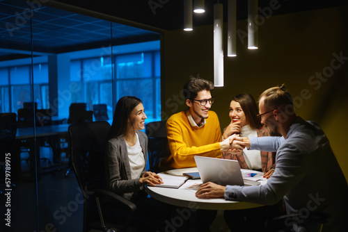 Workaholics businesspeople brainstorming financial company ideas analyzing strategy paperwork late at night in business office.Business Partners Discuss Financial Reports, Plan Investment Strategy.