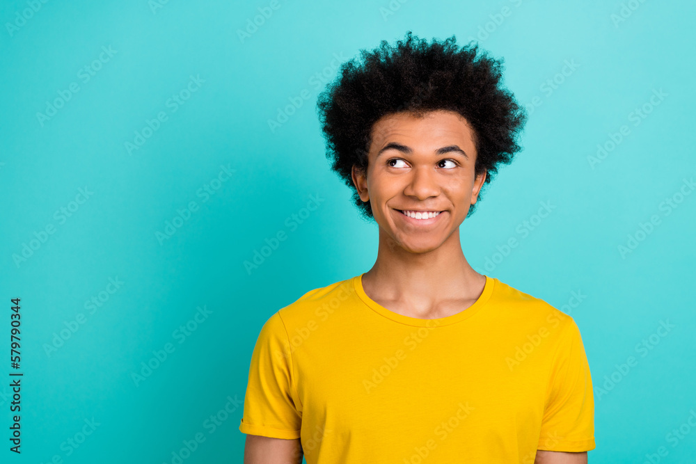 Portrait of friendly good mood guy with afro hairdo wear yellow t-shirt look at sale empty space isolated on shine teal color background Portrait of friendly good mood guy with afro hairdo wear yellow t-shirt look at sale empty space isolated on shine teal color background