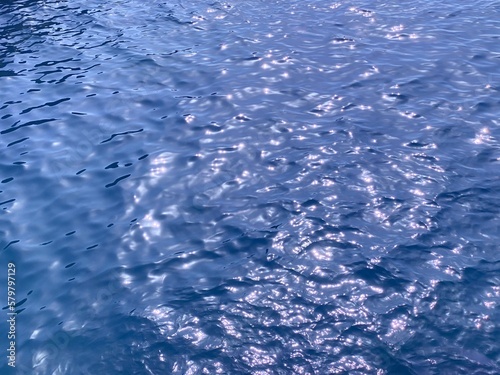 Blue water ocean waves shiny glittering surface. 