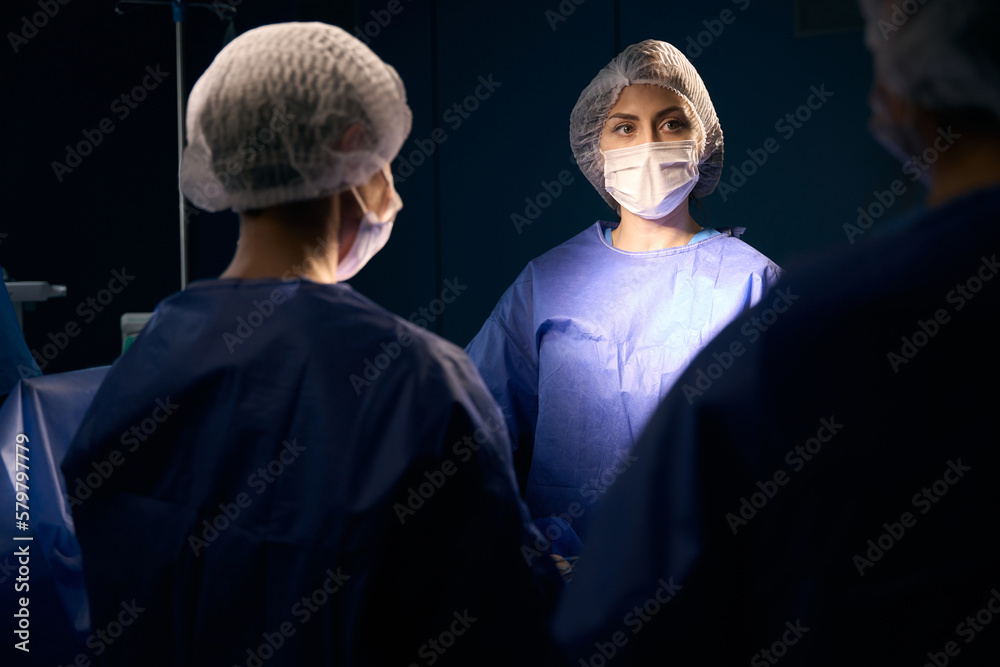Εκτύπωση καμβά Group of women in surgical uniforms stand at operating table
