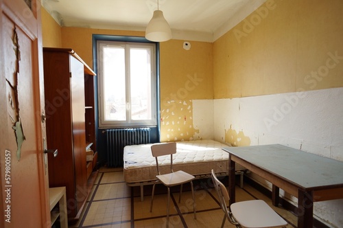 Slum landlord bedroom rental. Insalubrious bedroom. Abandoned room. Careless tenant. Destroyed wallpaper and door. photo