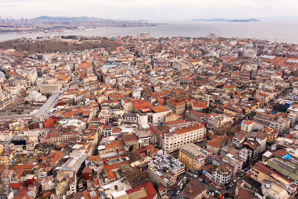 The New Mosque and Galata Bridge near Golden Horn in Istanbul, Turkey. Panoramic view from roofs of Buyuk Valide Han. Grand Bazaar and Beyazit Tower