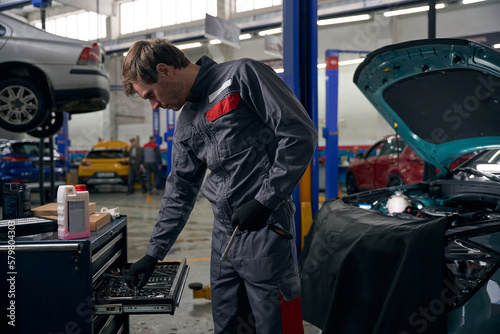 Man chooses tools for car repair in workshop