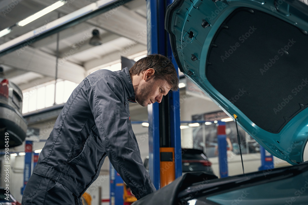 Male conducts full technical check of car Male conducts full technical check of car