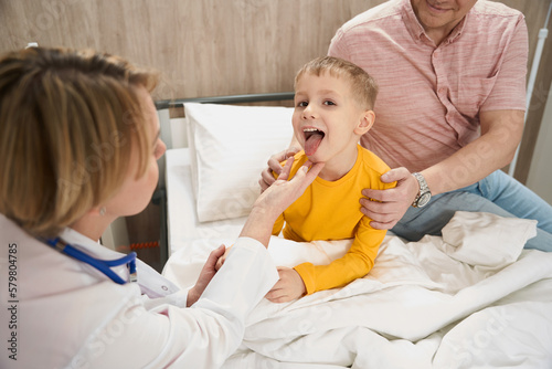 Blonde Caucasian child is getting consultation with doctor in children hospital