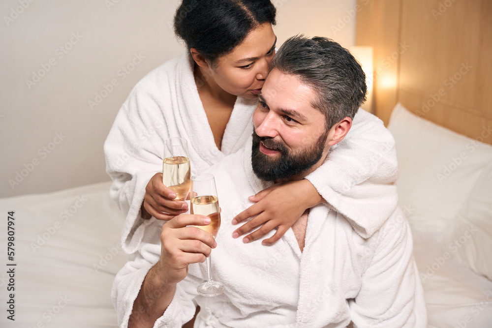 Romantic woman drinking sparkling wine with man