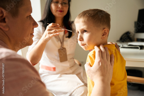 Child is getting professional examining his health in the kinder clinic