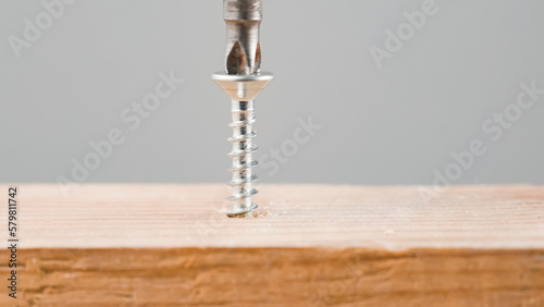 screwdriver and screw going in wood