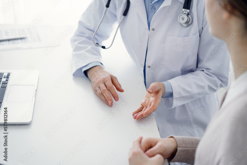 Doctor and patient discussing current health questions while sitting at the table in clinic office, only hands closeup. Medicine concept. Doctor and patient discussing current health questions while sitting at the table in clinic office, only hands closeup. Medicine concept.