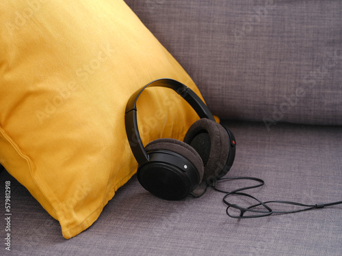 Headphones on a gray couch with yellow cushion