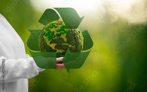 Fototapeta Naklejka Na Ścianę i Meble -  Woman holding a green planet Earth with recycling symbol	