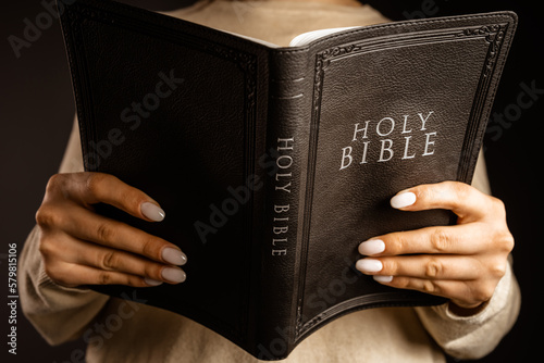 A woman holds a bible in her hand.