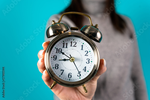 Woman holding an alarm clock in her hand