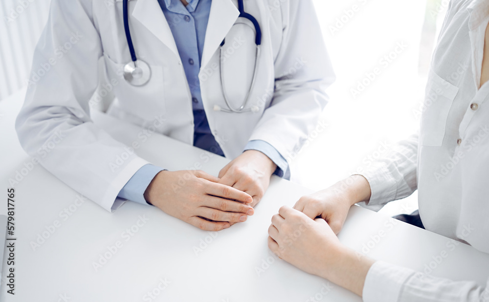 Doctor and patient discussing current health questions while sitting near of each other at the table in clinic, just hands closeup. Medicine concept Doctor and patient discussing current health questions while sitting near of each other at the table in clinic, just hands closeup. Medicine concept