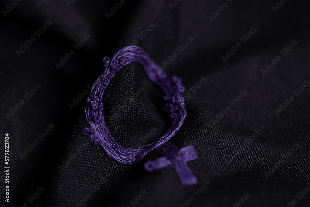 Fototapeta premium Símbolo de la mujer bordado en tela arrugada