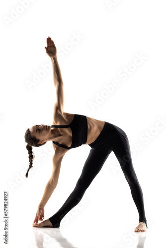 Fototapeta Naklejka Na Ścianę i Meble -  Portrait of young beautiful woman in black sportswear doing yoga practice.