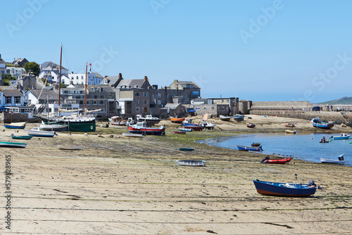 Isles of Scilly, United Kingdom - harbor of Hugh Town, St. Mary´s at low tide with many boats on the sand and town in the background