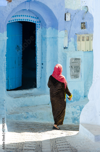 Moroccan woman walking in a street of Chefchaouen © Jean Isard