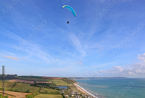 Paraglider flying above Beesands in Devon	 photo