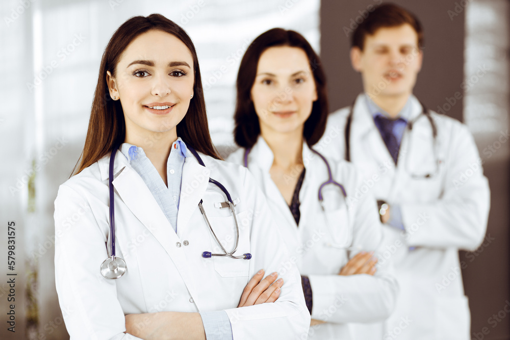 Group of young professional doctors is standing as a team with arms crossed in a hospital office and is ready to help patients. Group of young professional doctors is standing as a team with arms crossed in a hospital office and is ready to help patients.