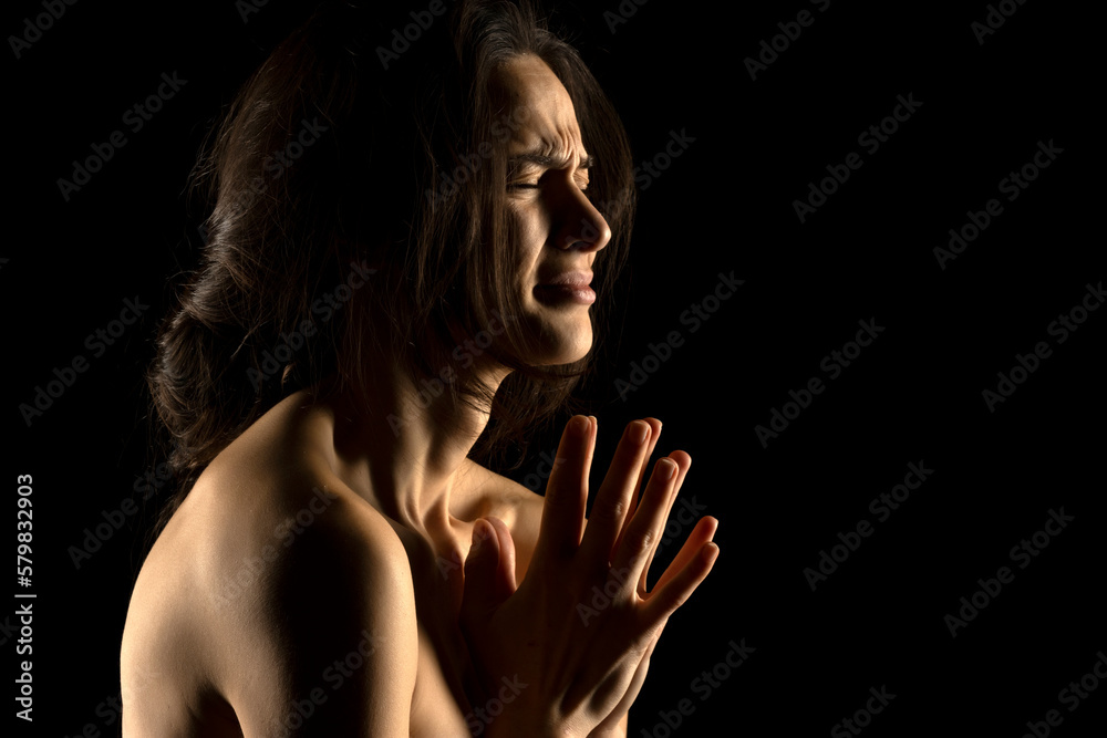 Obraz premium Silhouette of young unhappy prying woman on black background
