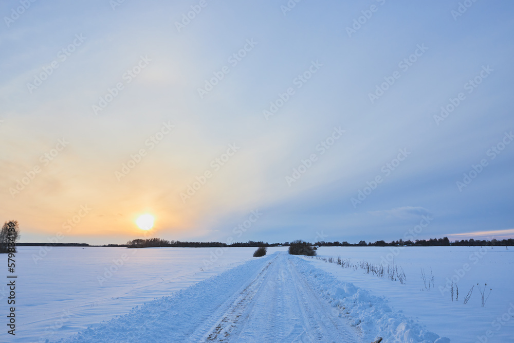 Sunset on a snowy road. Off-road on a snow-covered road.
