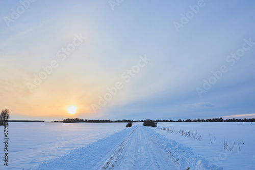 Sunset on a snowy road. Off-road on a snow-covered road. © Ihar