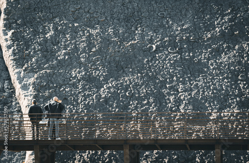 Tourists admiring the dalle aux ammonites (the ammonite slab or wall). Scientific name : Coroniceras multicostatum. Digne les Bains, Alpes de Haute Provence, France.