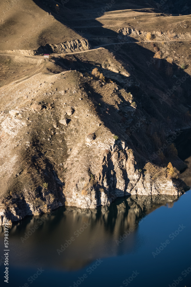 Rocky shore on the lake and reflection in the water in autumn at dawn, cliff break above the water Rocky shore on the lake and reflection in the water in autumn at dawn, cliff break above the water